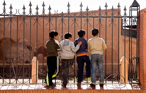 Boys hang out and chat next to the Ben Youssef Madrasa, what was an an Islamic college in Marrakech, Morocco.